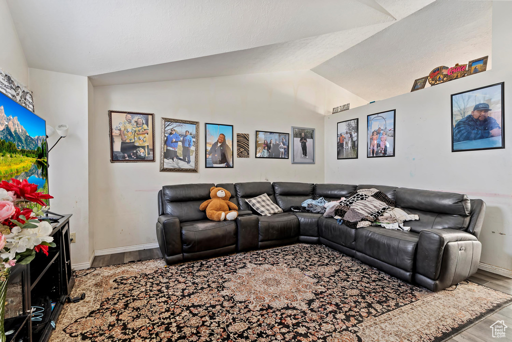 Living room with light hardwood / wood-style floors and lofted ceiling