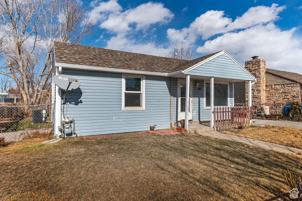 View of front facade with cooling unit, a front lawn, and a porch