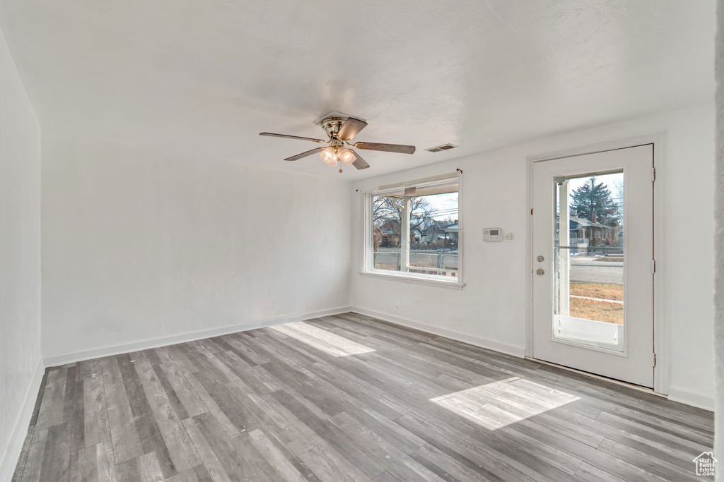 Empty room featuring light wood-type flooring and ceiling fan