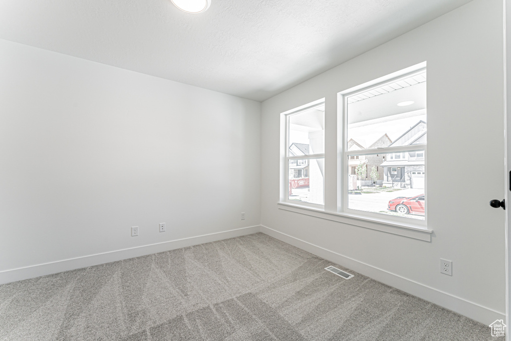 Carpeted empty room featuring baseboards