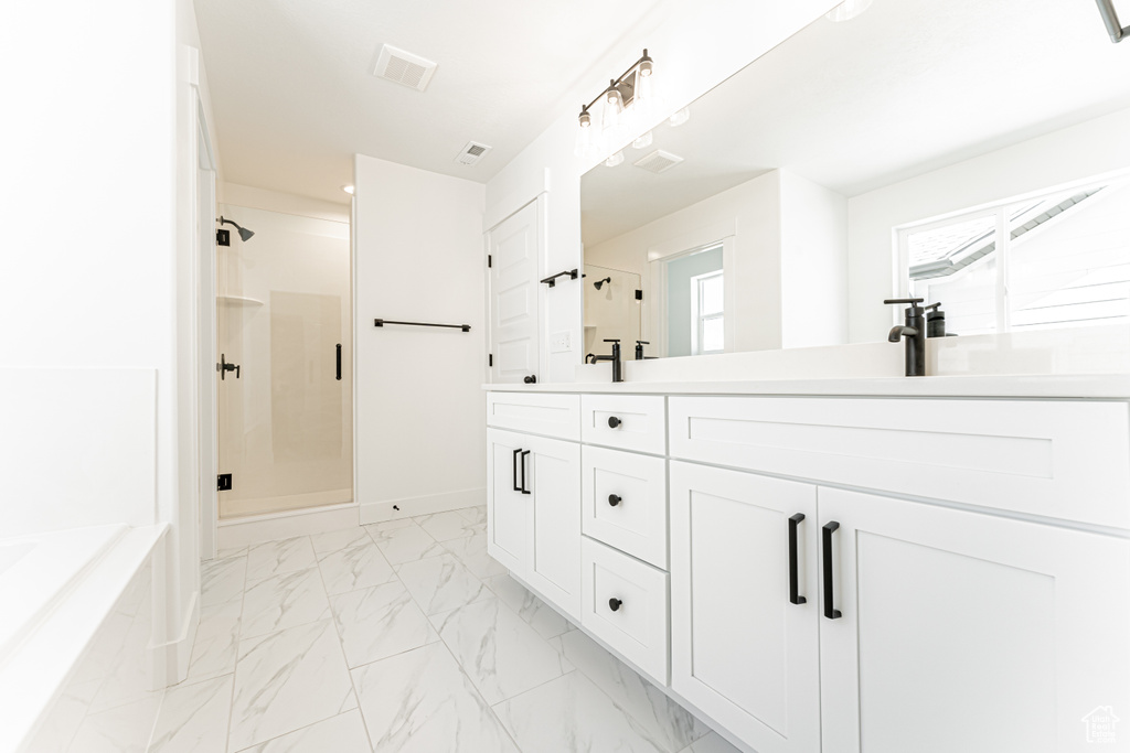 Full bath featuring a shower stall, marble look tiles, double vanity, and a garden tub