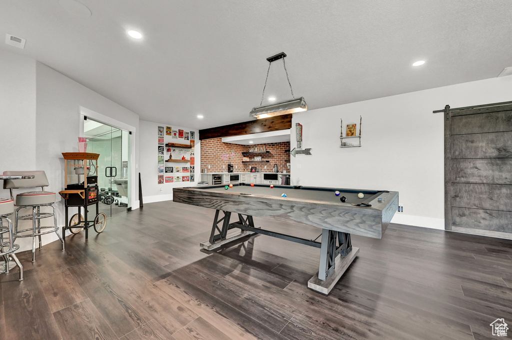 Playroom with billiards, baseboards, visible vents, a barn door, and dark wood-type flooring