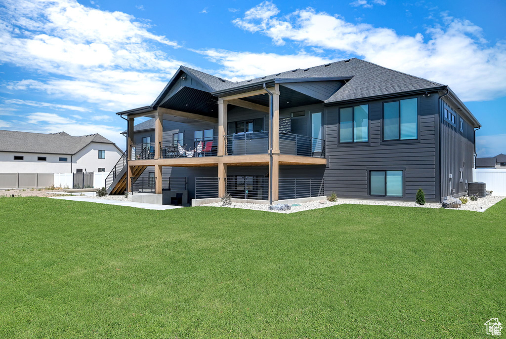 Back of house featuring stairs, a lawn, and fence