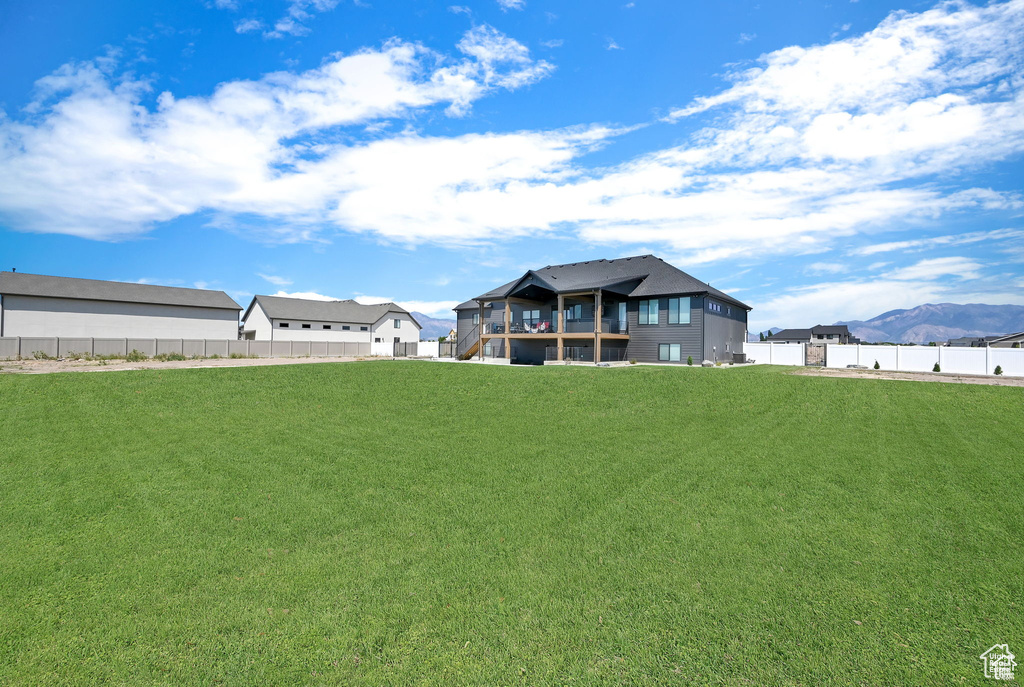 View of yard featuring a mountain view and fence