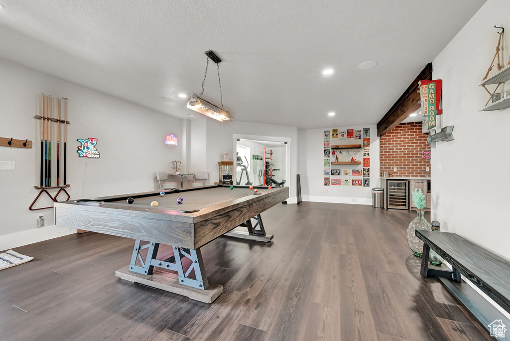 Rec room featuring recessed lighting, a bar, baseboards, dark wood-type flooring, and wine cooler