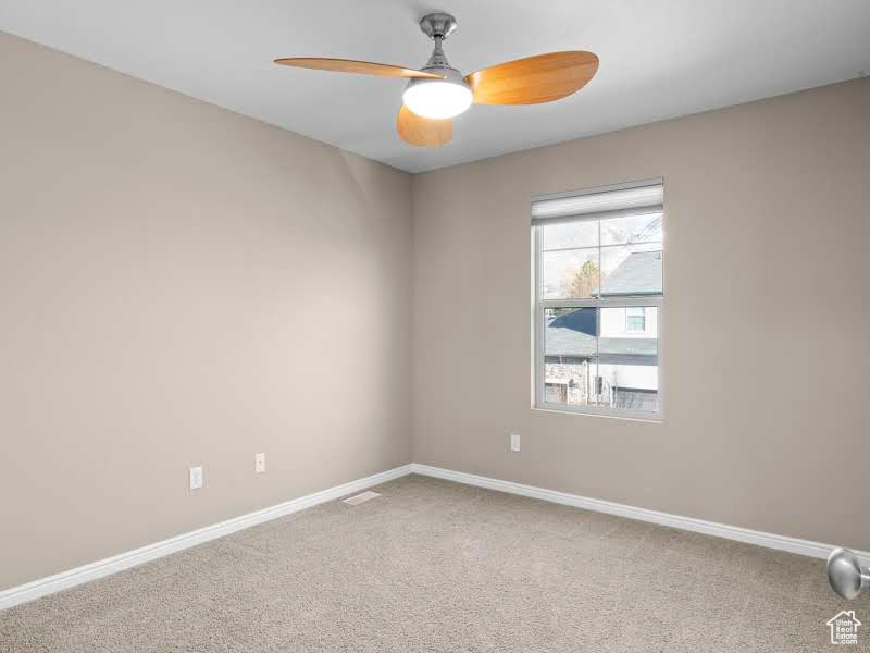 Carpeted spare room with ceiling fan