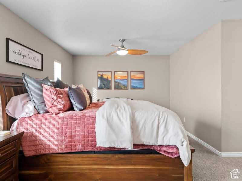 Carpeted bedroom with ceiling fan