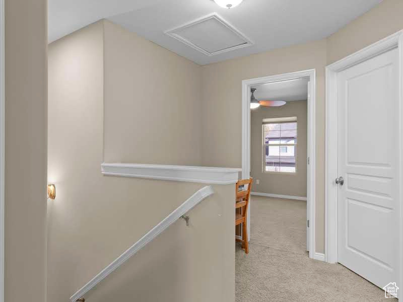 Hallway featuring light colored carpet