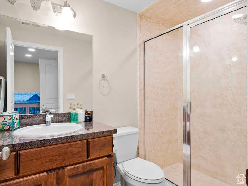 Bathroom featuring vanity, toilet, and walk in shower