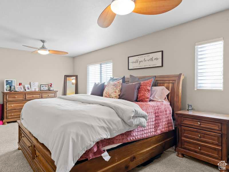 Carpeted bedroom with ceiling fan