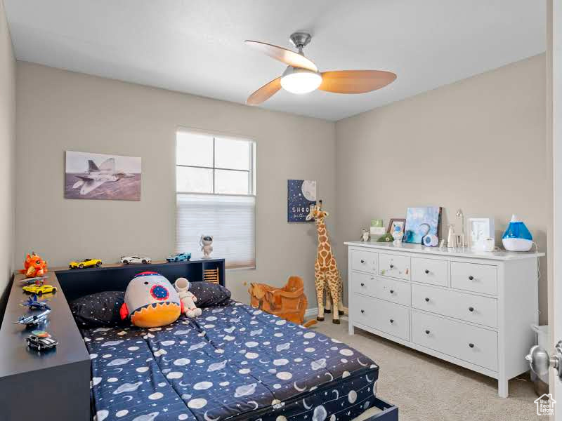 Carpeted bedroom featuring ceiling fan