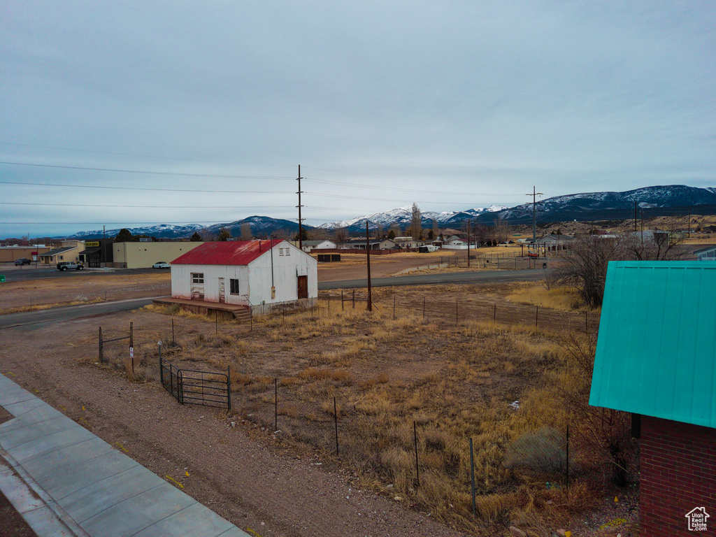 View of yard featuring fence, an outdoor structure, and a mountain view