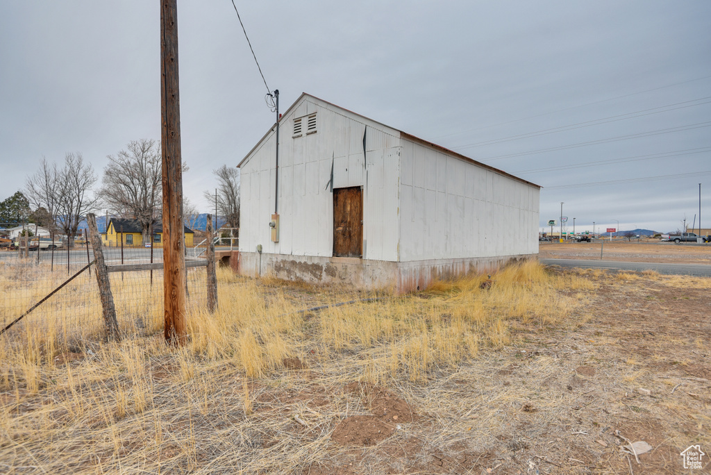 View of outdoor structure featuring an outbuilding and fence