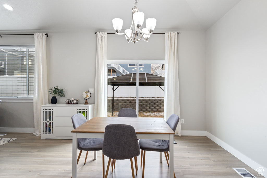 Dining room featuring light wood-type flooring and a chandelier