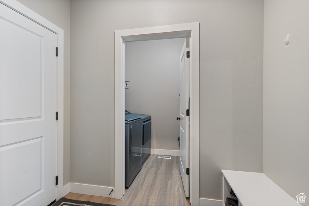 Interior space featuring washing machine and dryer and light hardwood / wood-style flooring