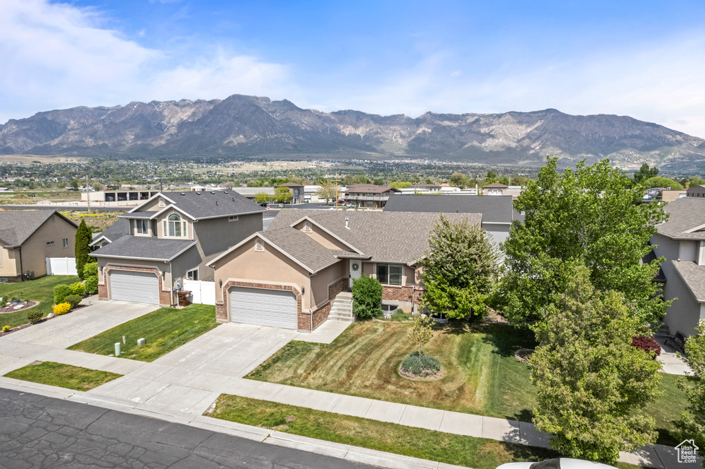 View of front of house featuring roof with shingles, a mountain view, driveway, a residential view, and stucco siding