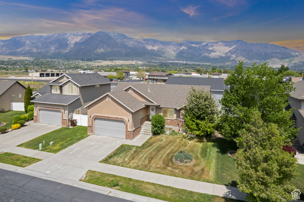 View of front of home featuring brick siding, stucco siding, and a mountain view