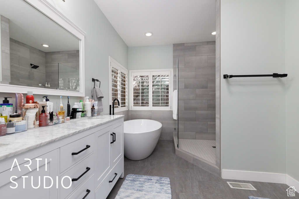 Bathroom with tile patterned floors, plus walk in shower, and vanity