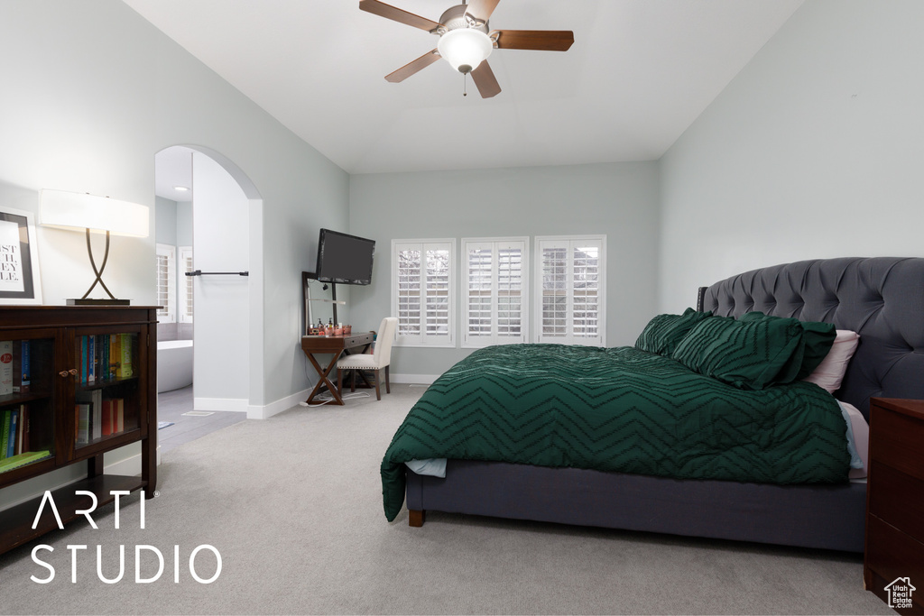 Carpeted bedroom with ceiling fan and lofted ceiling