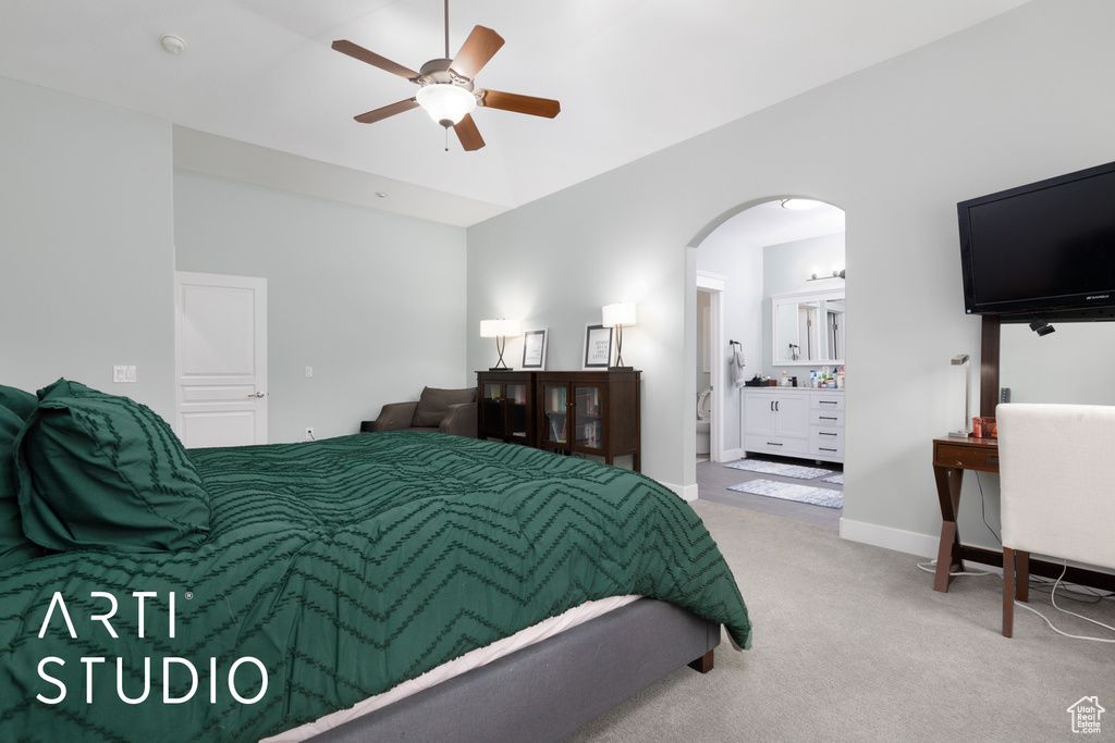 Bedroom with light carpet, lofted ceiling, ceiling fan, and connected bathroom