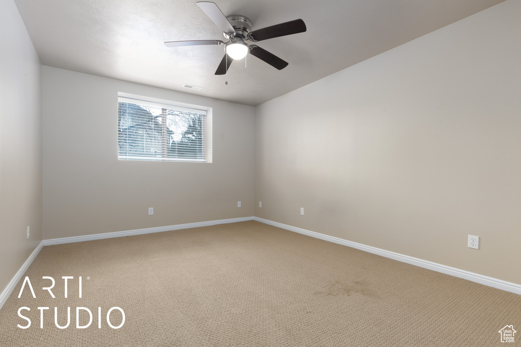 Carpeted empty room featuring ceiling fan