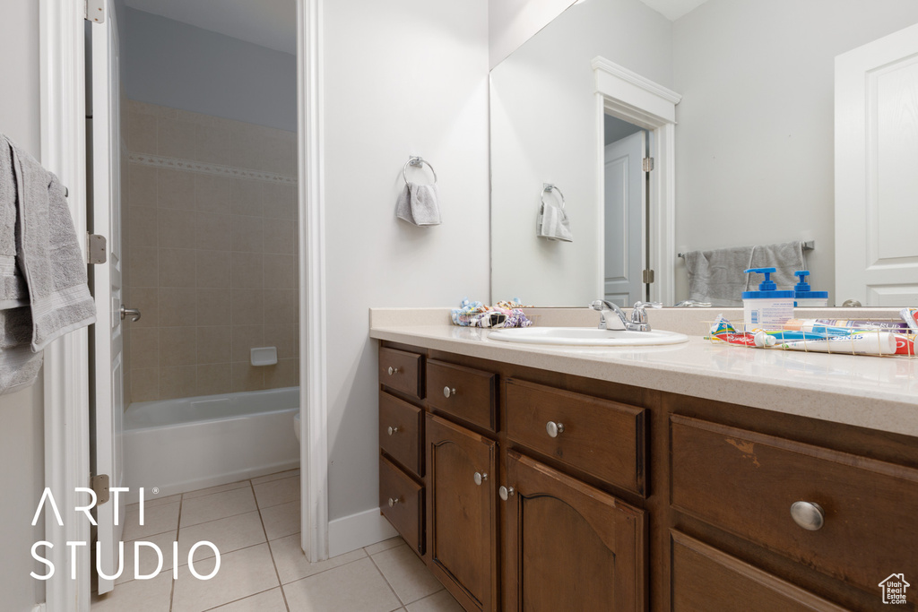 Bathroom featuring tile patterned floors, vanity, and tiled shower / bath