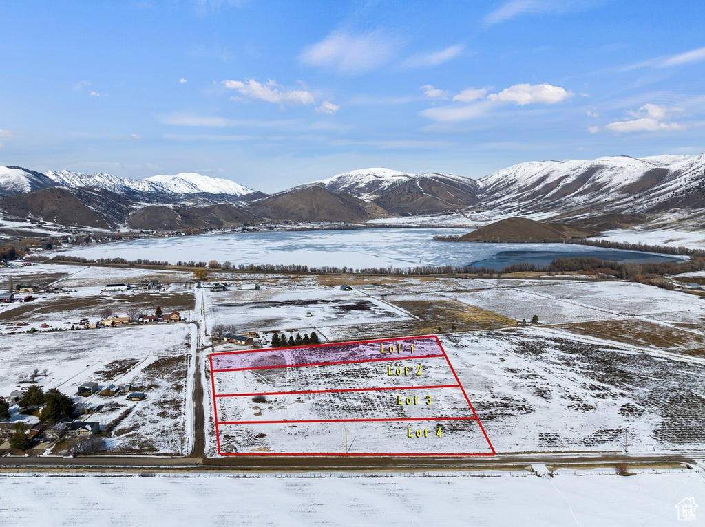 Snowy aerial view with property parcel outlined and a mountain view