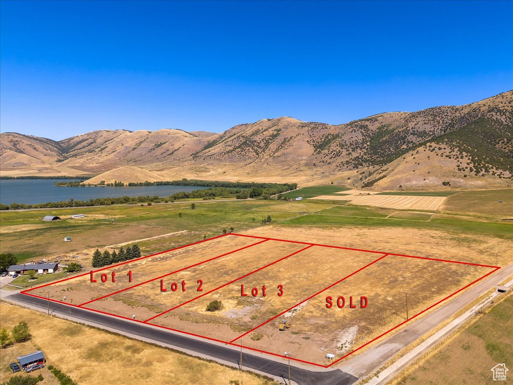 Birds eye view of property with a water and mountain view