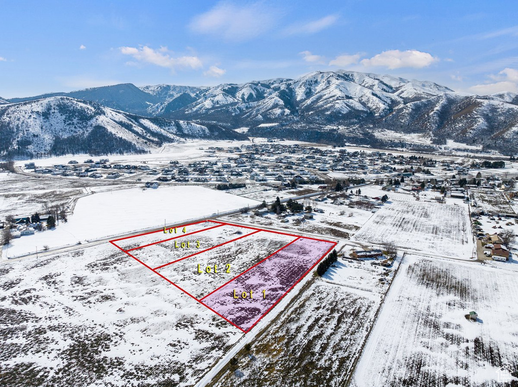 Snowy aerial view with property boundaries highlighted and a mountain view