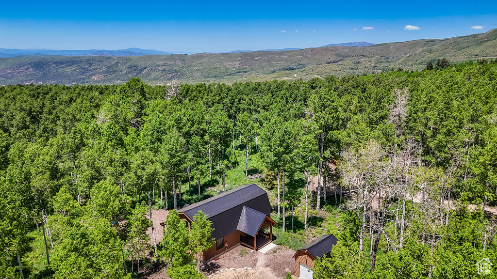 View from above of property featuring a heavily wooded area and a mountain backdrop