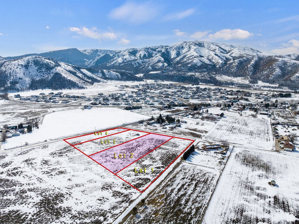 Snowy aerial view featuring property boundaries highlighted and a mountain view