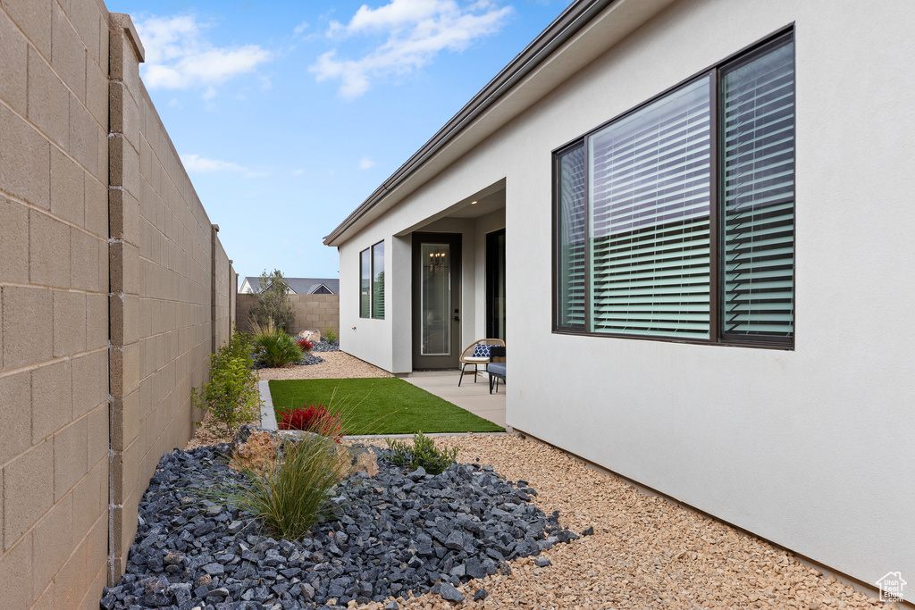 Exterior space featuring a patio area, a fenced backyard, and stucco siding