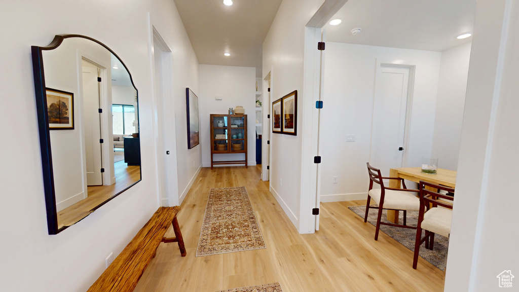Hallway with recessed lighting, baseboards, and light wood-style floors