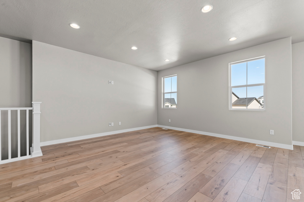 Spare room featuring recessed lighting, light wood-style floors, and baseboards