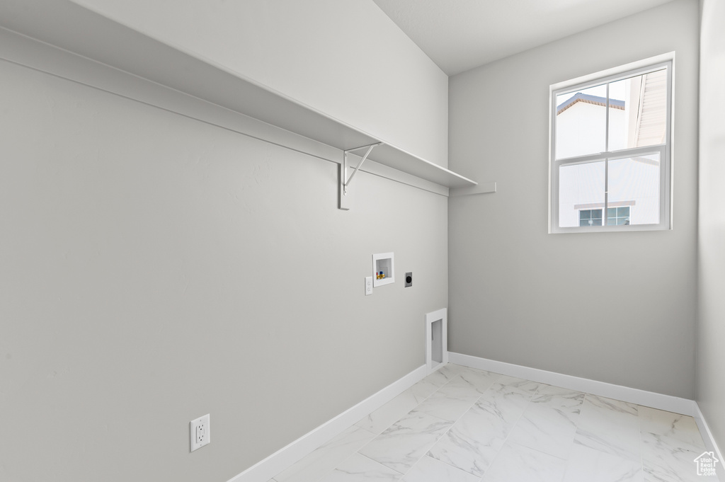 Laundry area featuring electric dryer hookup, washer hookup, baseboards, and light marble finish floors