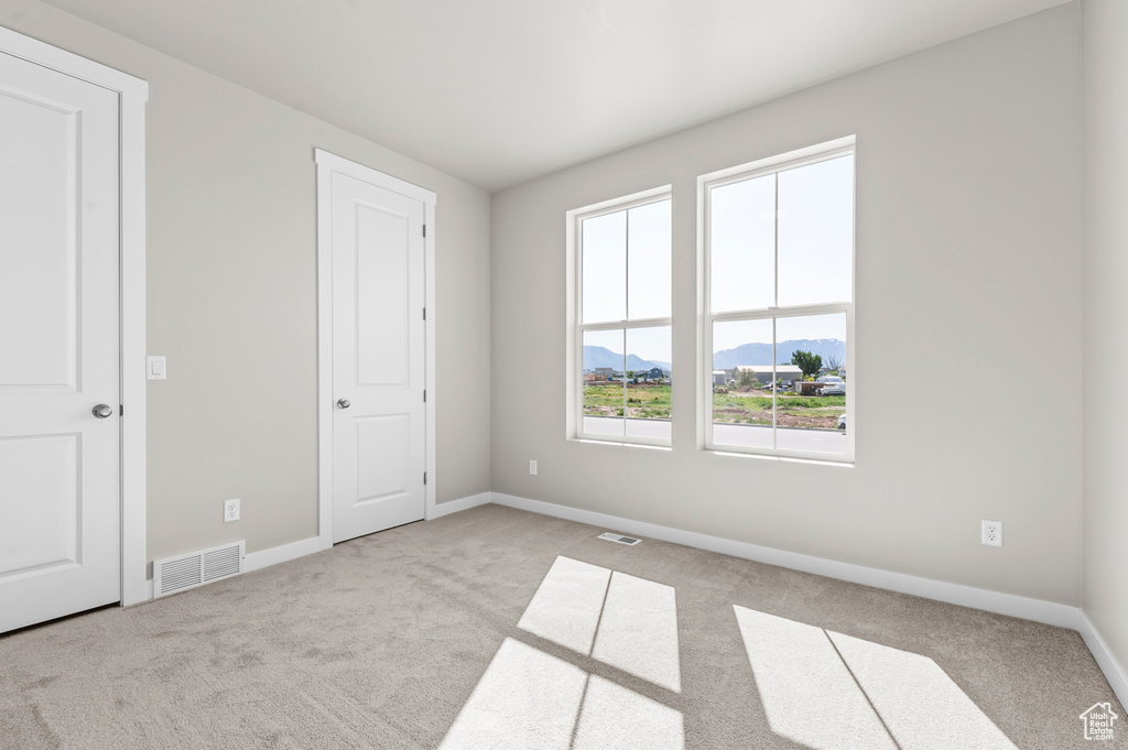 Unfurnished bedroom featuring carpet flooring, a mountain view, and baseboards