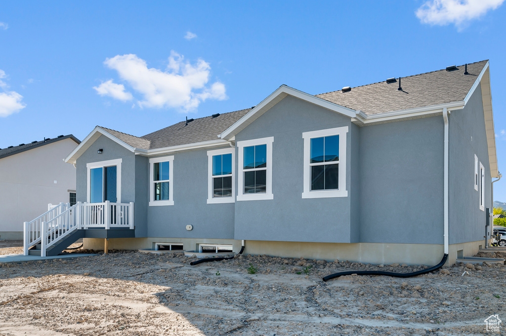 Back of house with a shingled roof