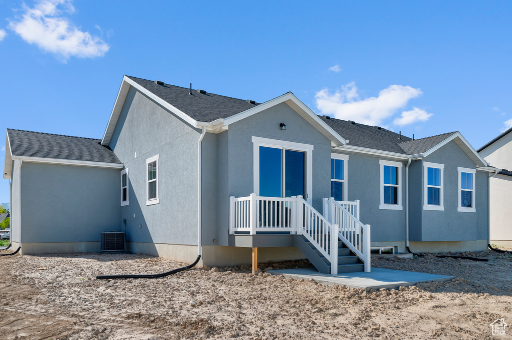 View of front facade featuring central AC unit and stucco siding