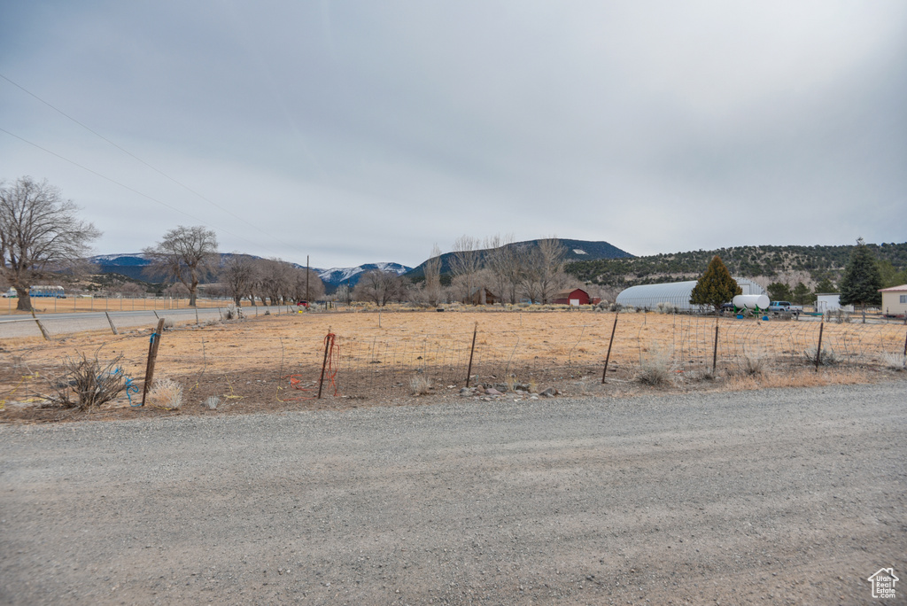 View of yard with fence, a mountain view, and a rural view