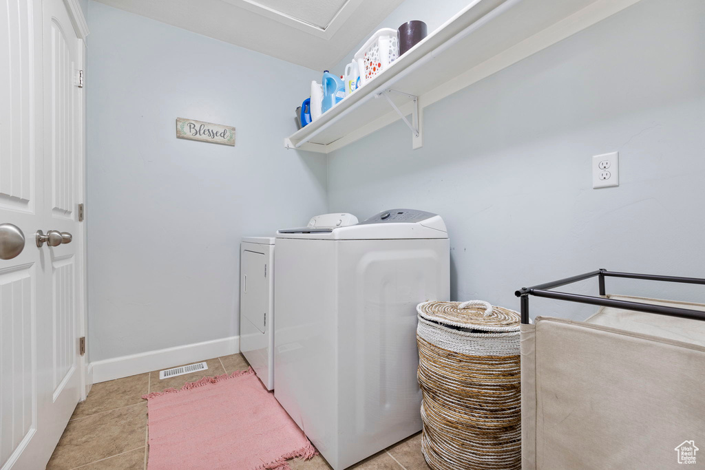 Laundry area featuring visible vents, light tile patterned flooring, laundry area, independent washer and dryer, and baseboards