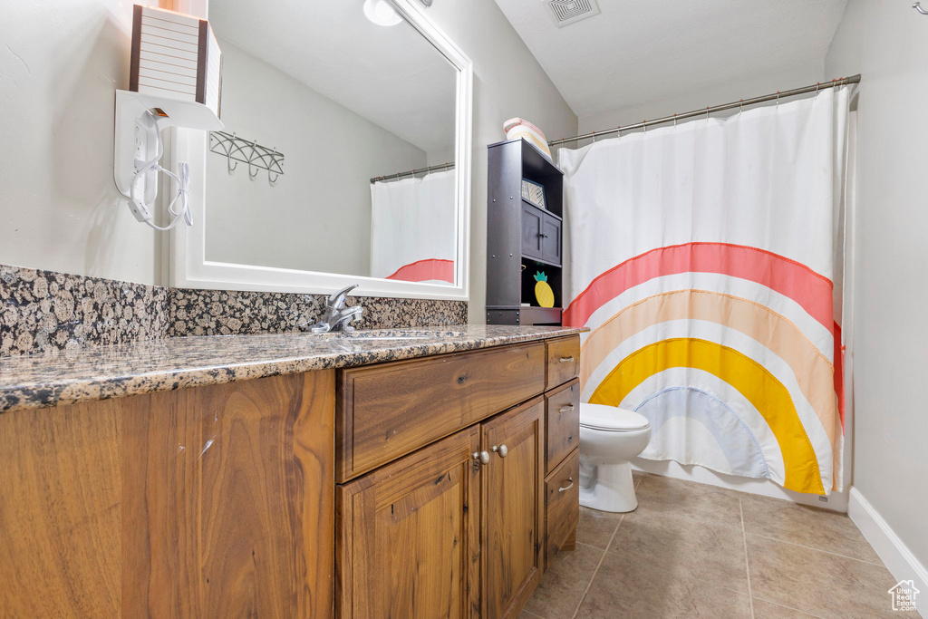 Full bathroom featuring visible vents, vanity, toilet, and tile patterned floors