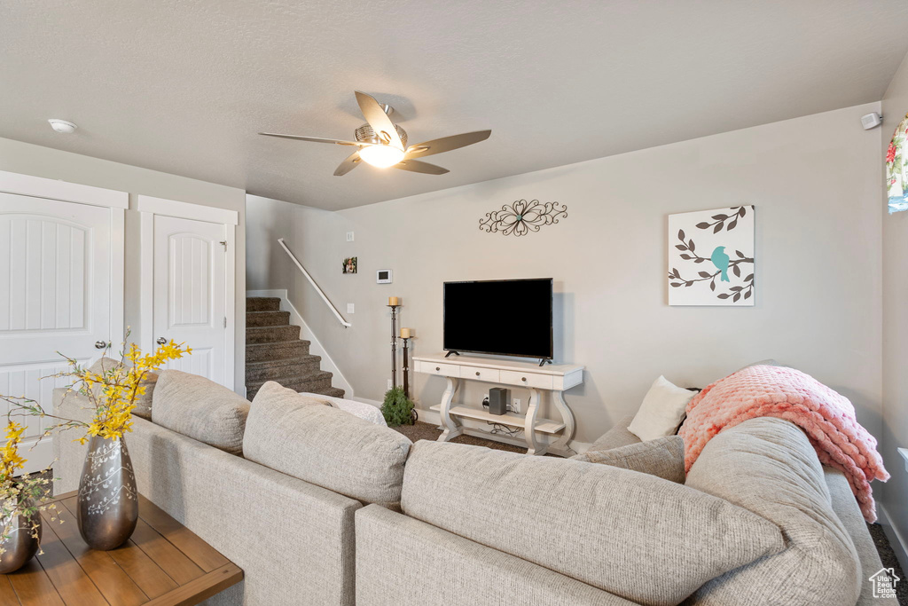 Living room with stairs and a ceiling fan