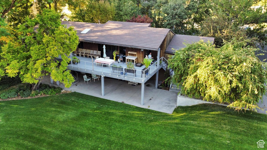 Back of property with a yard and a wooden deck