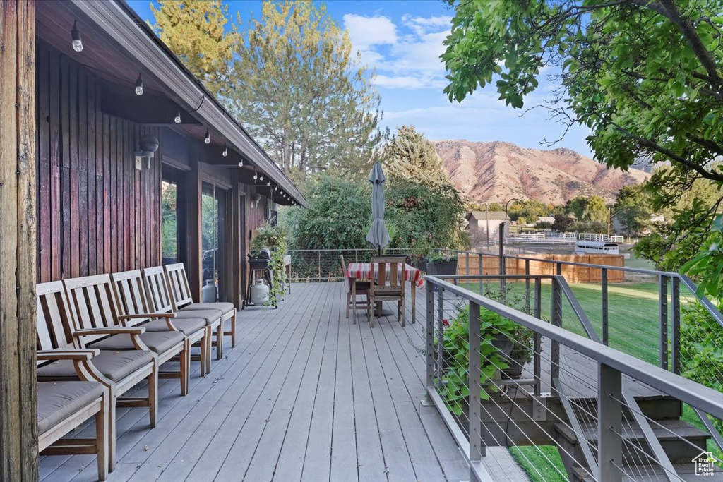 Deck featuring a mountain view and a lawn