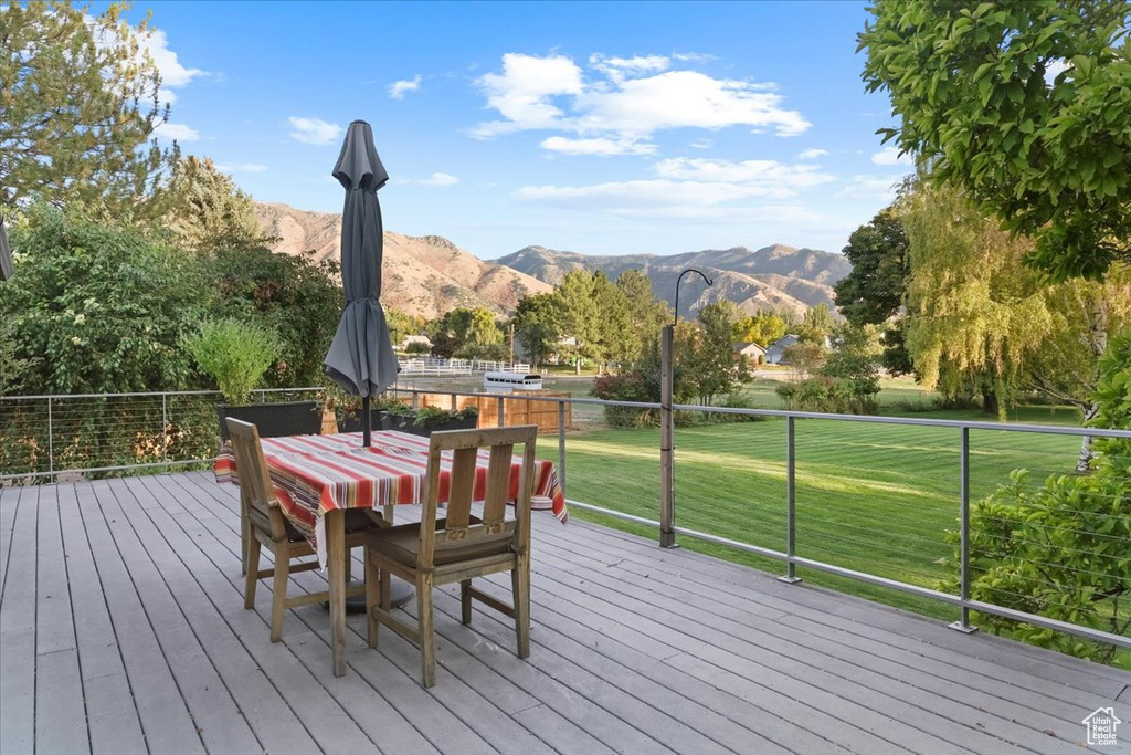 Deck with a mountain view and a lawn