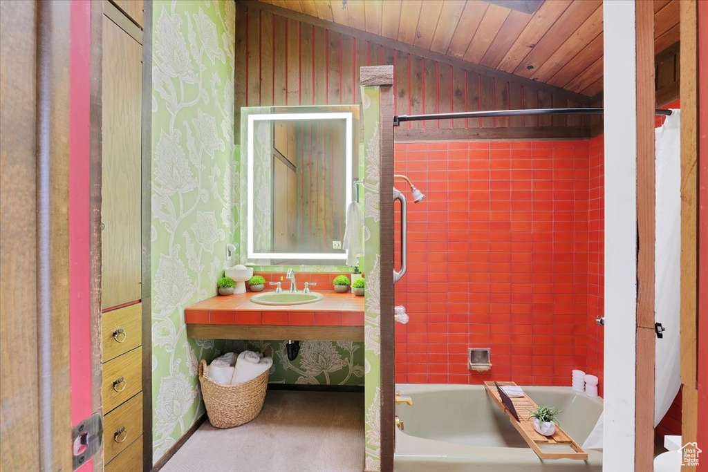 Bathroom featuring tiled shower / bath combo, vaulted ceiling, sink, and wooden ceiling