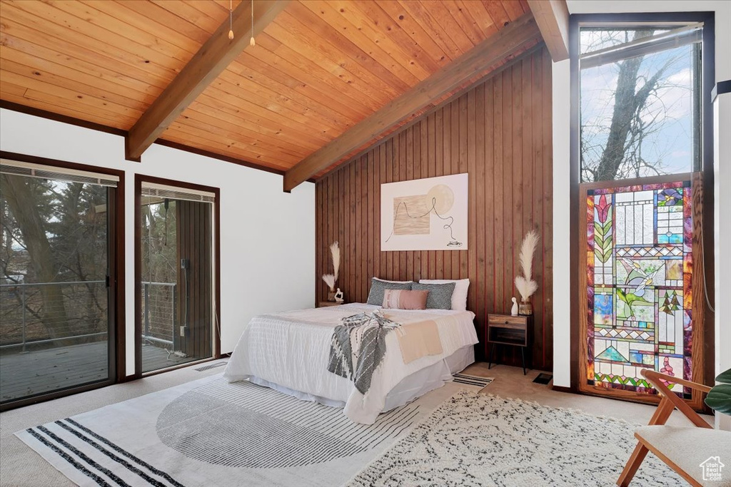 Carpeted bedroom with wooden ceiling, high vaulted ceiling, wooden walls, access to outside, and beam ceiling