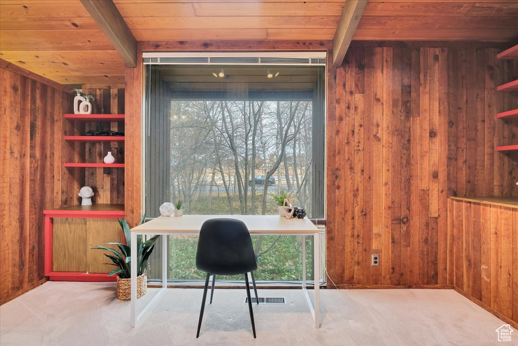 Office space featuring wood ceiling, light colored carpet, and wooden walls