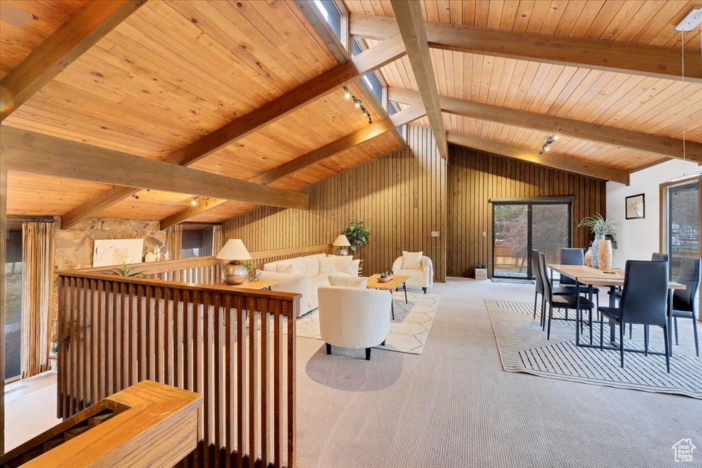 Carpeted living room featuring lofted ceiling with beams and wood ceiling