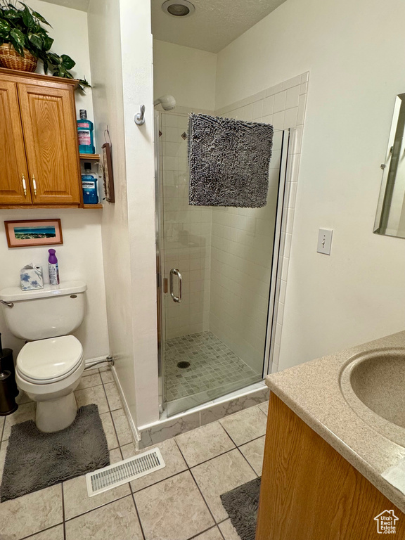 Full bathroom with visible vents, toilet, tile patterned floors, vanity, and a shower stall